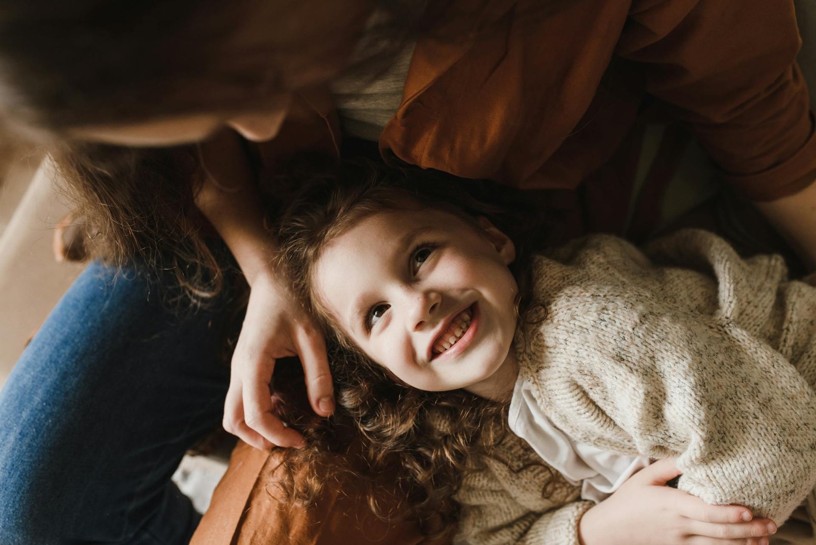 girl lying on mother's lap