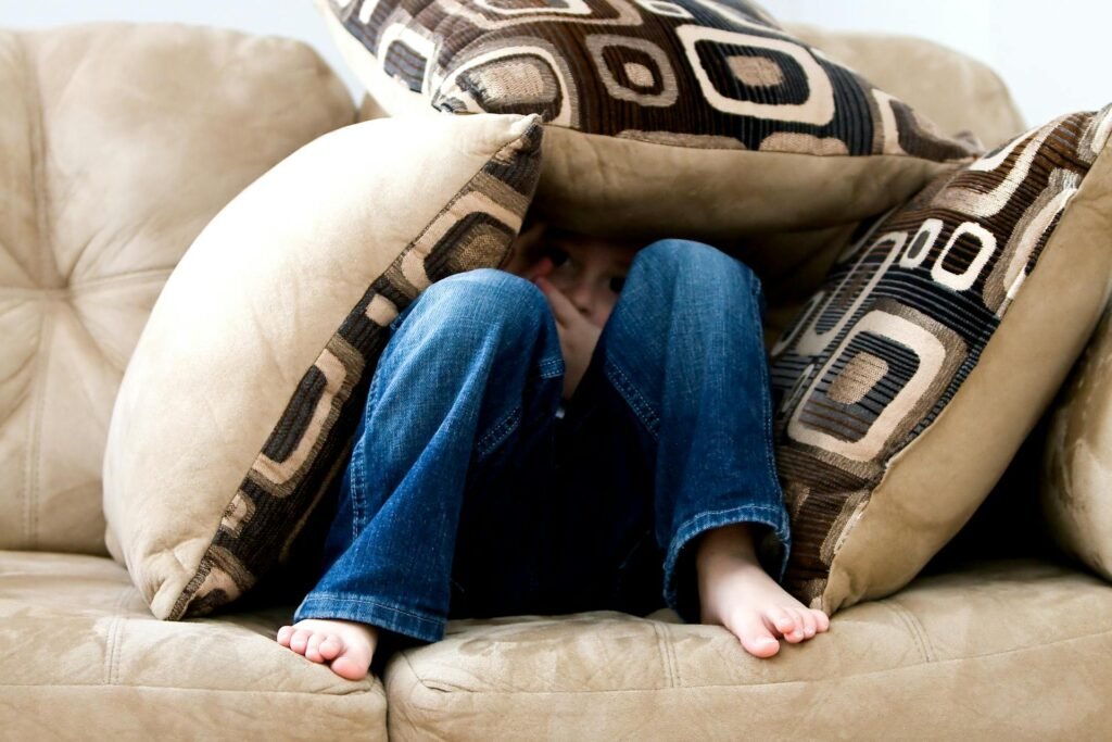 Inner Child Work for Parents: A Beginner’s Guide kid hiding on pillows