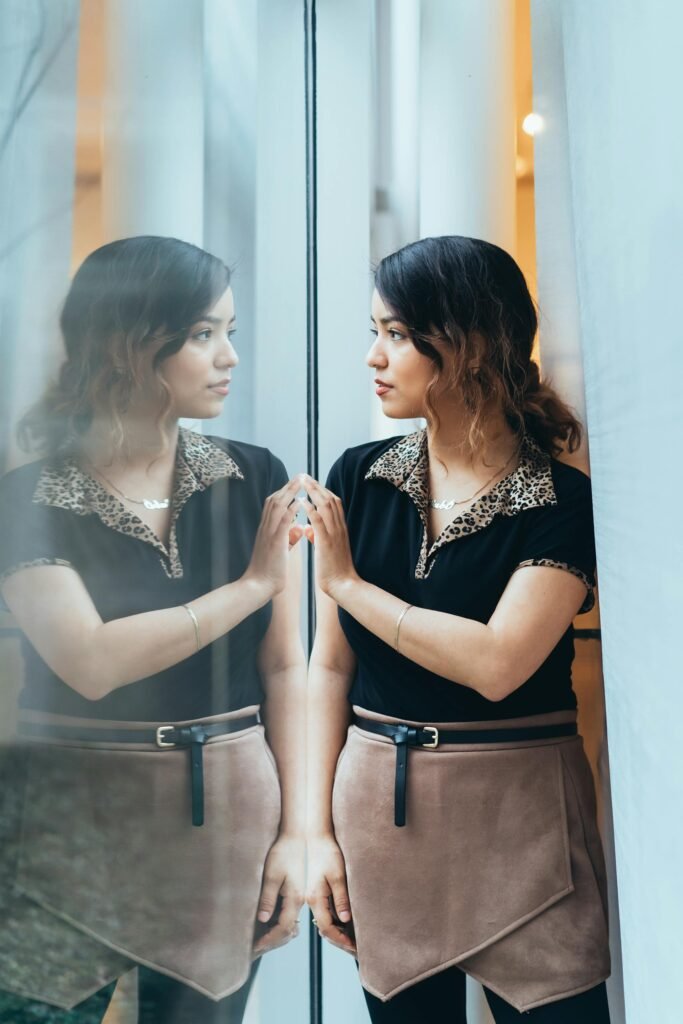 Parenting Stress to Thriving: How to Shift Out of Constant Stress a woman looking at her reflection on a bay window