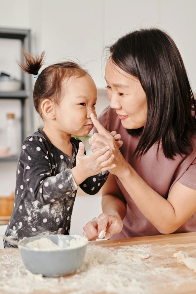 Why Self-Compassion for Parents Is the Key to Better Parenting photo of a mother and her daughter playing with flour